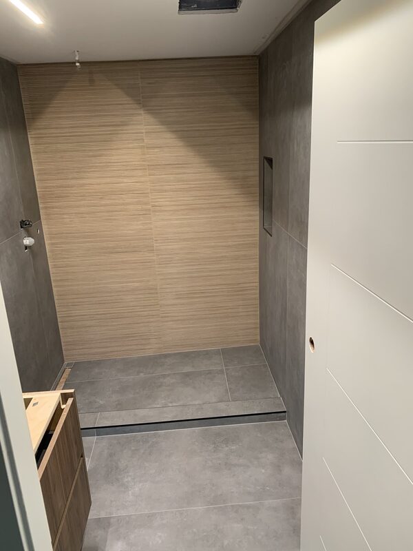 A collection of bathroom tile and stone installations across the Lower Mainland — large-format porcelain slab showers, marble-look wet rooms, subway tile tub surrounds and custom recessed niches.