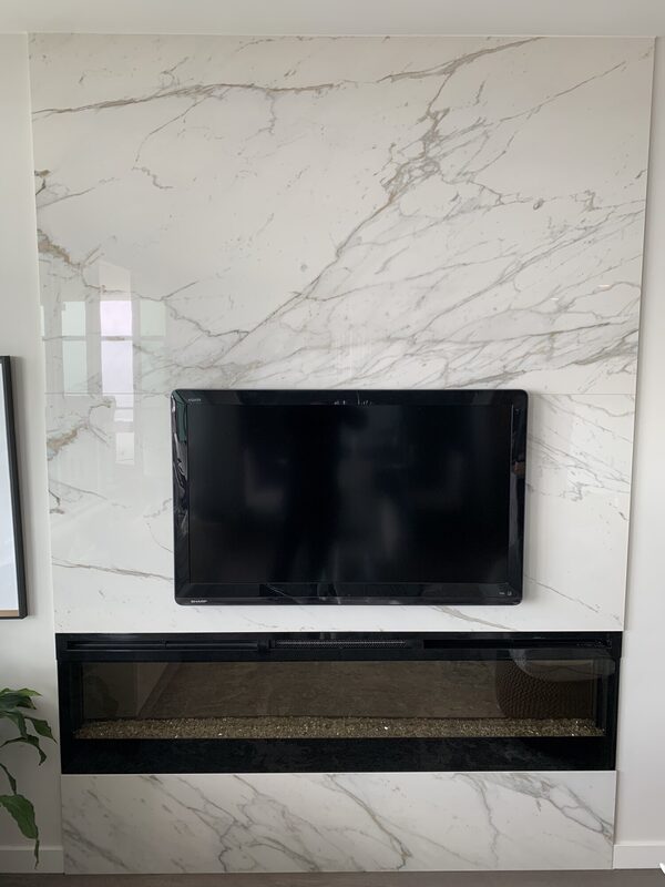 Porcelain and stone slab fireplace surrounds — book-matched veining, mitred returns and floating hearths.