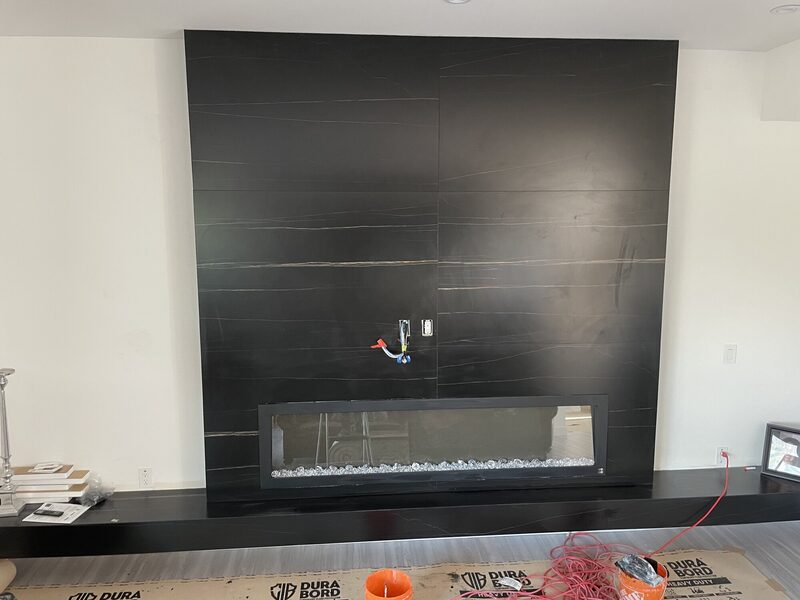 Mitred porcelain slab return being fitted tight to a firebox opening