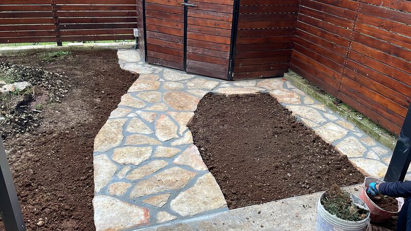 Irregular cleft flagstone path set through a garden with mortared joints