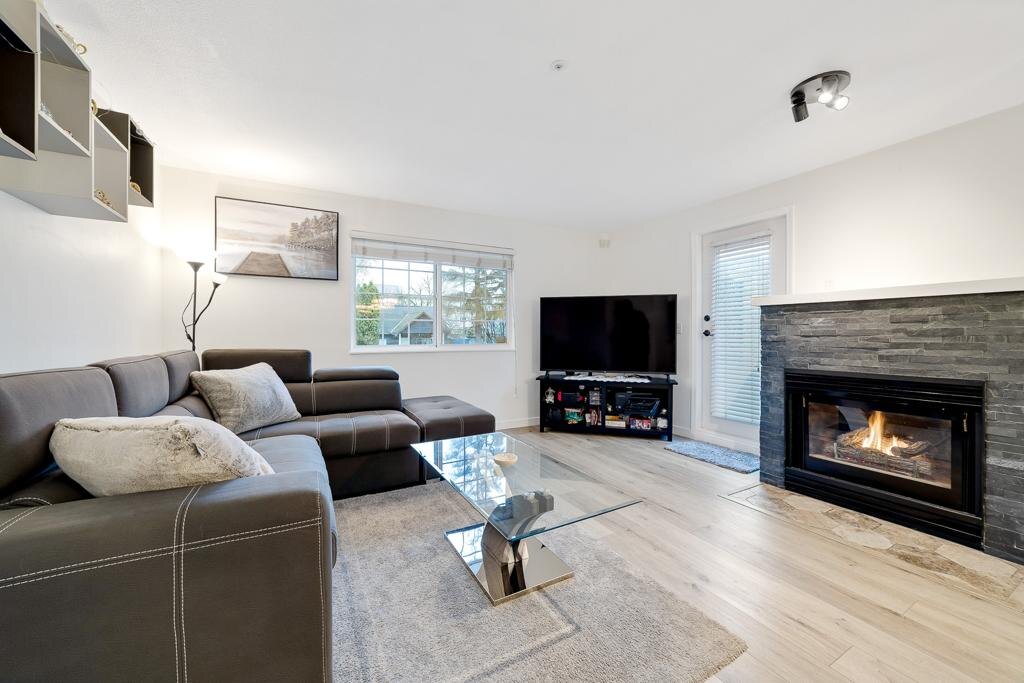 A full condo renovation — granite kitchen counters with glass mosaic backsplash, a stacked stone fireplace wall, new flooring throughout and a rebuilt bathroom.