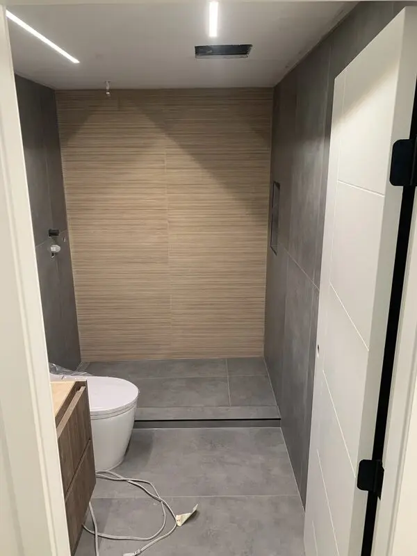 Finished bathroom in matte concrete-look porcelain with wood-grain porcelain shower wall and floating vanity