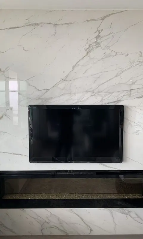 Full-height book-matched Calacatta porcelain slab fireplace wall with a linear gas insert