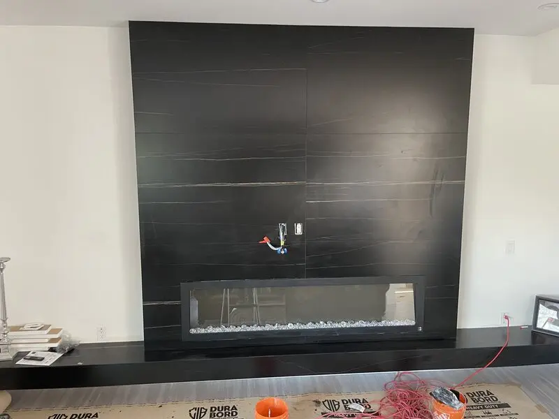 Mitred porcelain slab return being fitted tight to a firebox opening