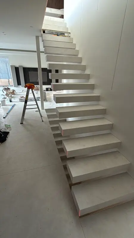 Floating stair with stone-look porcelain treads mitred on all visible edges
