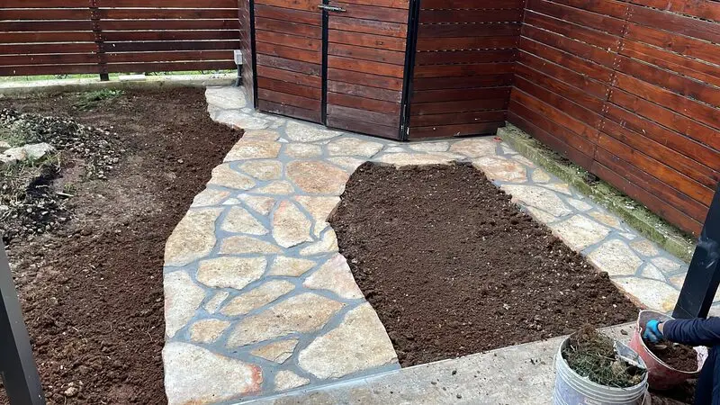 Irregular cleft flagstone path set through a garden with mortared joints
