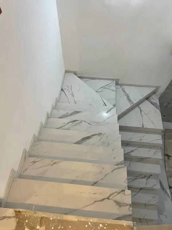 Marble stair flight in white Statuario-look stone with mitred nosings and matching landing