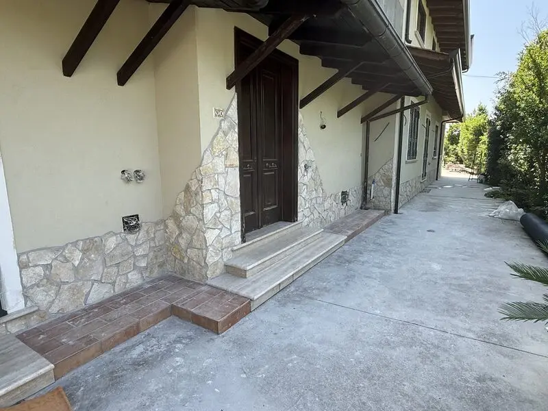 Cream natural stone wainscot with a matching solid stone entry step