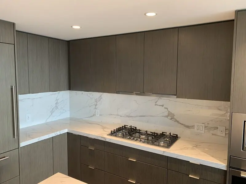 Full-height Calacatta-look slab backsplash and counter above walnut cabinetry