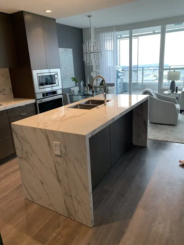 Marble-look slab island and counters with veining carried across the mitred edge