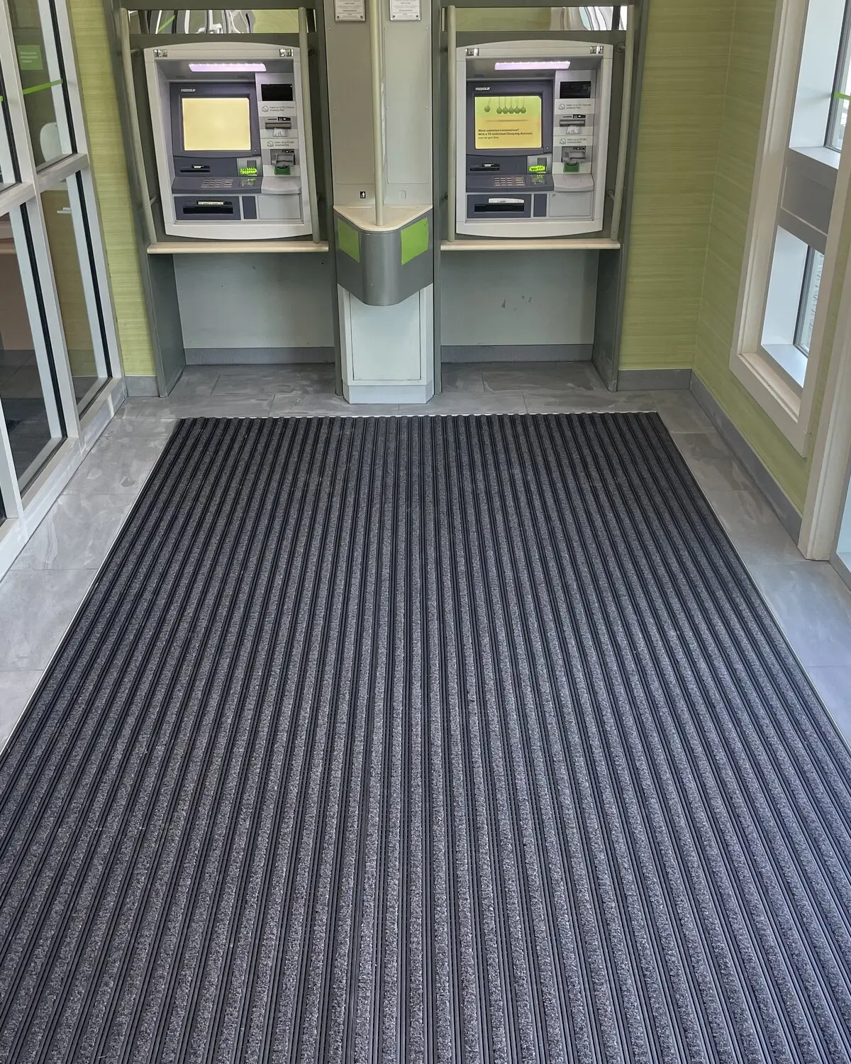 Bank vestibule with recessed heavy-duty ribbed entry matting framed by porcelain tile